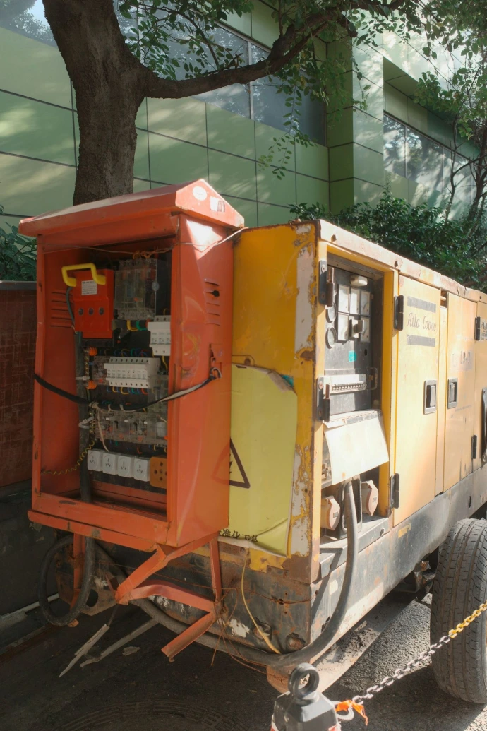 Yellow industrial generator with open electrical panel